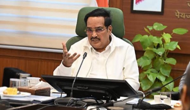C. R. Patil gesturing while speaking at a government conference table, with a departmental backdrop behind him.