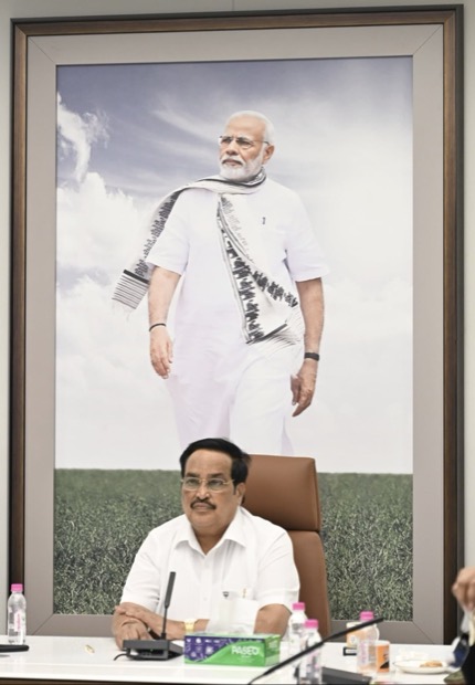 C. R. Patil seated at his desk in the Ministry of Jal Shakti, beneath a large framed photograph of the Prime Minister.