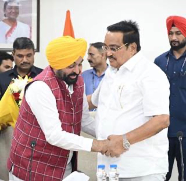 C. R. Patil shaking hands with a visiting Chief Minister at an indoor meeting, with officials standing behind them.
