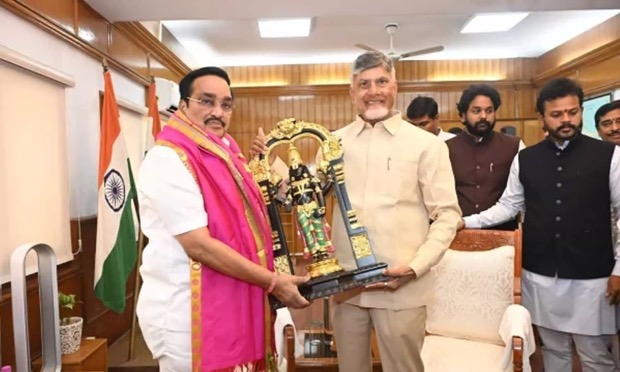 A wider view of C. R. Patil presenting a memento at an official meeting, showing the room and the officials present.