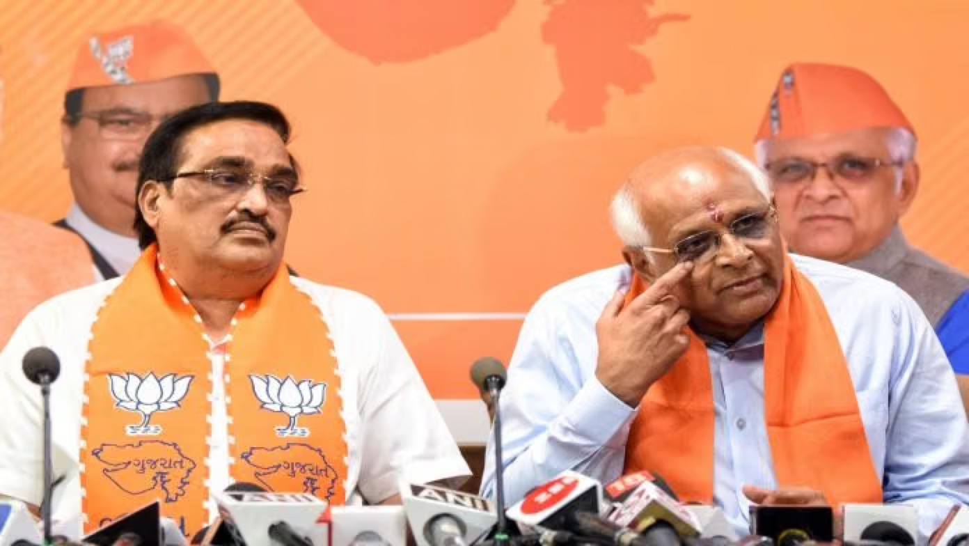C. R. Patil at a press conference alongside the Chief Minister of Gujarat, with party microphones on the table in front of them.