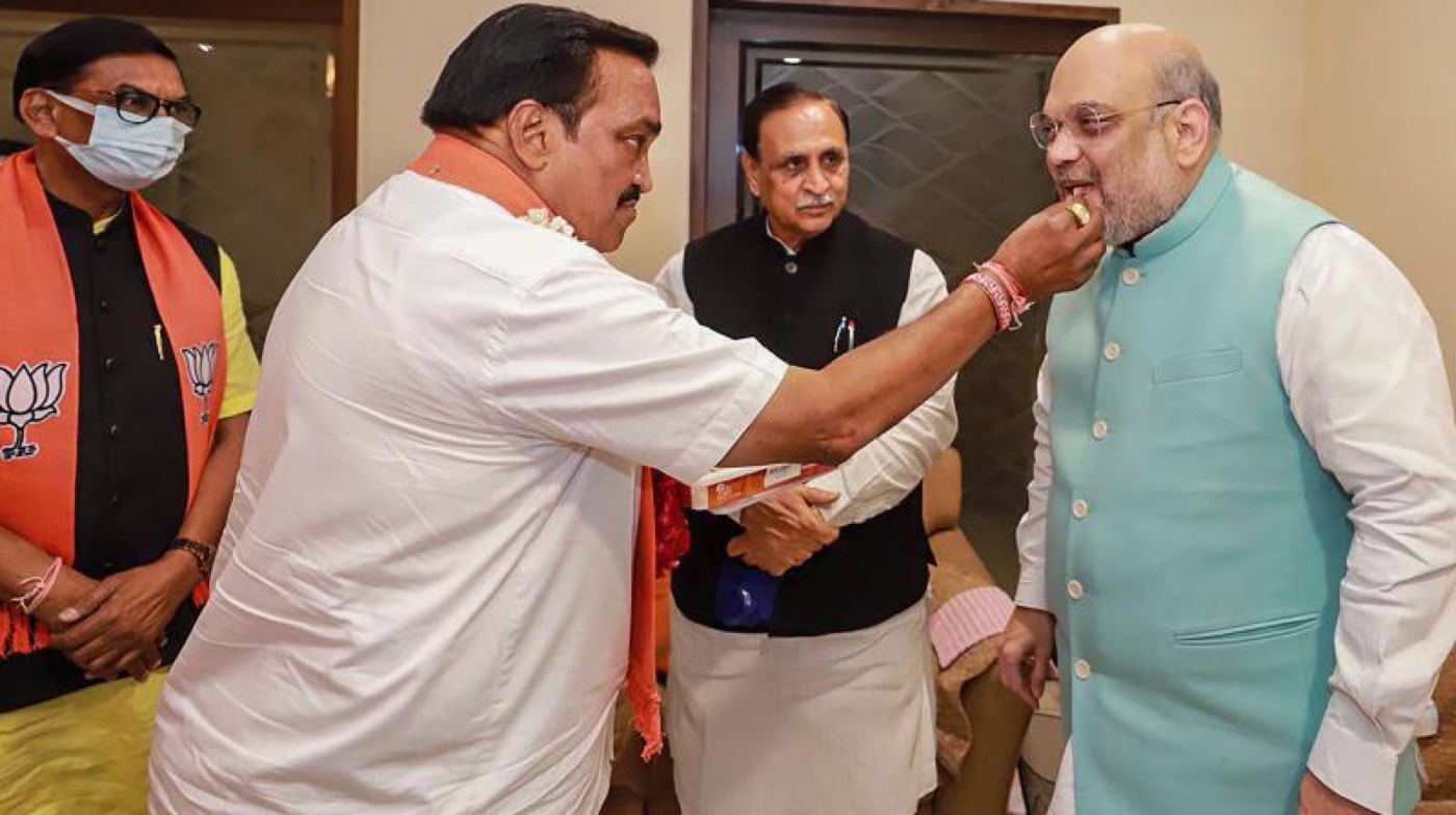 C. R. Patil offering sweets in greeting to Union Home Minister Amit Shah, with another senior leader seated between them.
